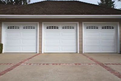 Professional garage door installation technician completing comprehensive system setup with precision mounting of tracks, springs, rollers, and safety hardware for Louisville residential garage door service
