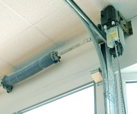 Professional direct-drive jackshaft opener installation with technician mounting equipment beside torsion bar for modern Louisville garage upgrade