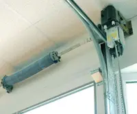 Professional direct-drive jackshaft garage door opener installation showing wall-mounted motor system beside door on torsion bar for maximum ceiling clearance and space-saving design in Louisville garages
