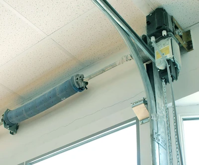 Wall-mounted jackshaft garage door opener installed beside torsion shaft