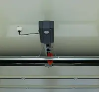 Derby Strong Garage Doors professional installing screw-drive opener in Louisville garage showing threaded steel rod mechanism and powerful motor for fast, heavy-duty operation