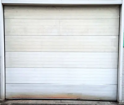 Professional garage door technician removing and replacing damaged garage door panel sections, showing expert panel replacement service to restore structural integrity, weather sealing, and enhanced curb appeal for Louisville residential properties
