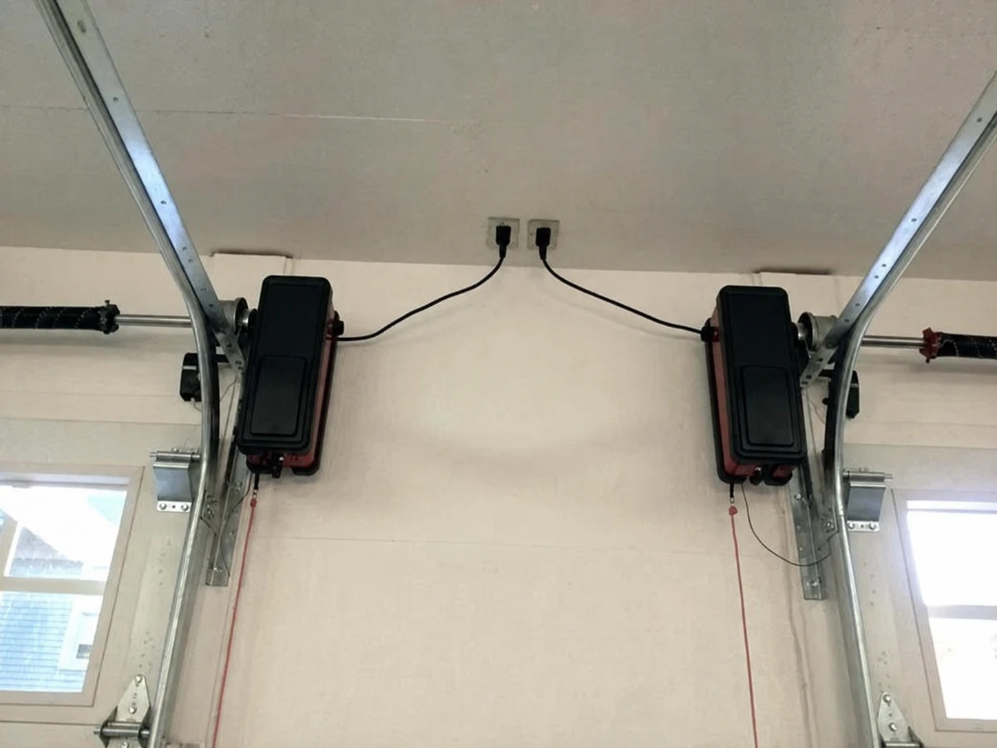 Two side-mounted garage door openers beside separate torsion shafts