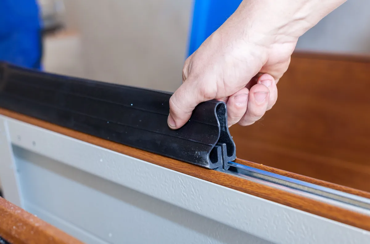 Garage door weatherstripping and insulation detail to reduce drafts and energy loss.